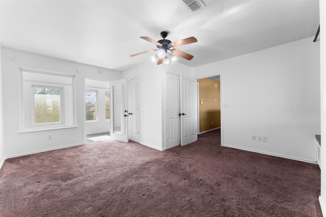 unfurnished bedroom featuring ceiling fan and dark colored carpet