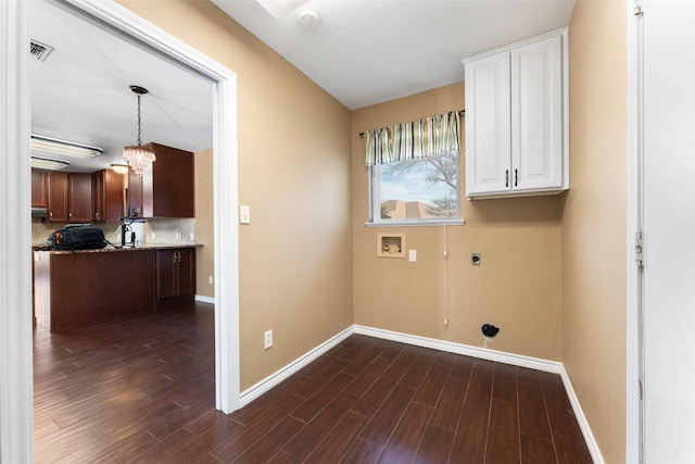 washroom featuring dark hardwood / wood-style flooring, cabinets, a notable chandelier, hookup for a washing machine, and electric dryer hookup