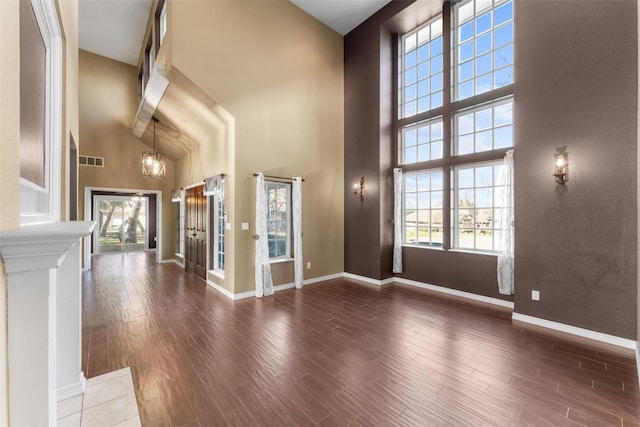 foyer with dark hardwood / wood-style flooring and a towering ceiling