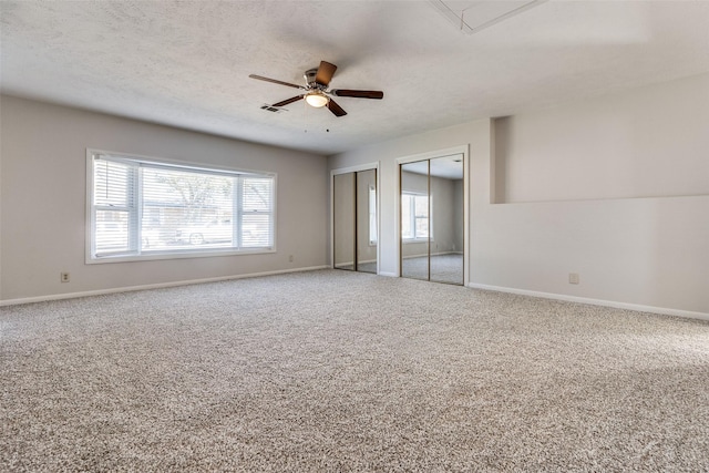 carpeted spare room featuring a textured ceiling and ceiling fan