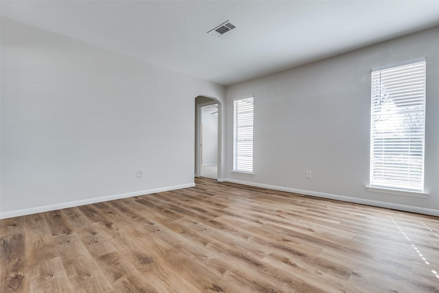 spare room featuring light hardwood / wood-style floors and plenty of natural light