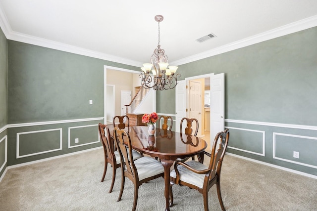 carpeted dining room with a notable chandelier and ornamental molding