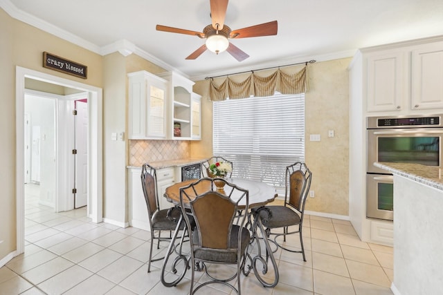 dining space with ceiling fan, ornamental molding, and light tile patterned flooring