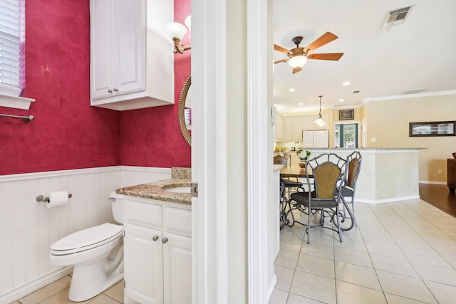 bathroom featuring tile patterned floors, vanity, toilet, ceiling fan, and crown molding