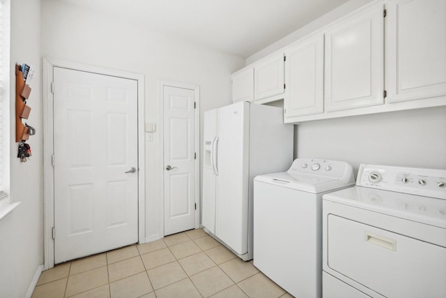 laundry area with washer and clothes dryer, light tile patterned floors, and cabinets