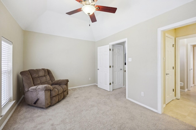 sitting room featuring vaulted ceiling, ceiling fan, light carpet, and a tray ceiling