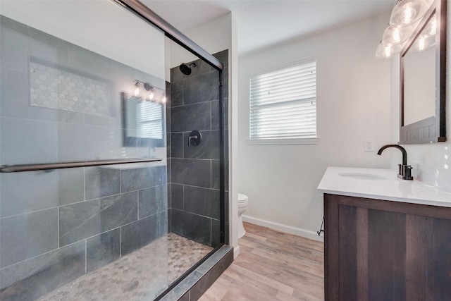 bathroom with vanity, toilet, walk in shower, and wood-type flooring