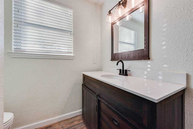 bathroom with wood-type flooring, toilet, and vanity