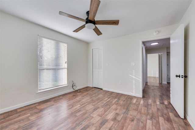 empty room featuring ceiling fan, hardwood / wood-style floors, and a healthy amount of sunlight