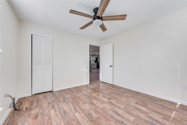 unfurnished bedroom featuring light hardwood / wood-style floors, a closet, and ceiling fan