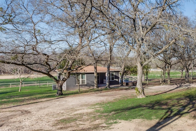 view of front facade featuring a front lawn and a rural view