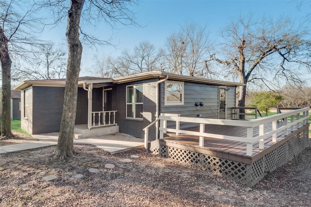 rear view of property featuring covered porch and a deck