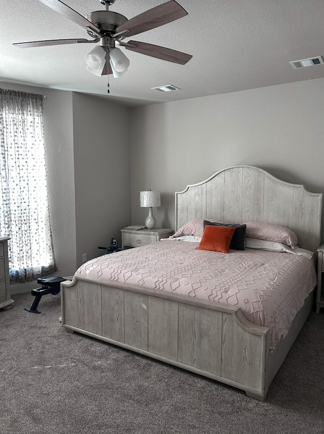 bedroom featuring ceiling fan, carpet flooring, and a textured ceiling