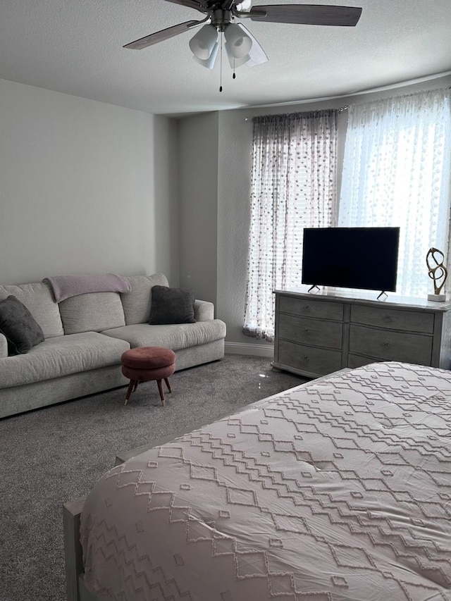 carpeted bedroom with ceiling fan and a textured ceiling