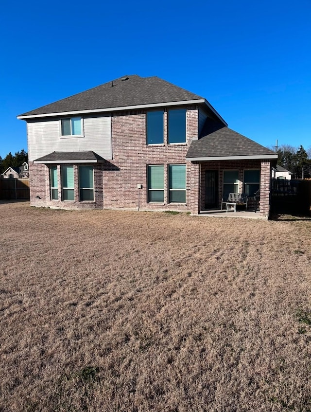 back of house with a patio area and a yard