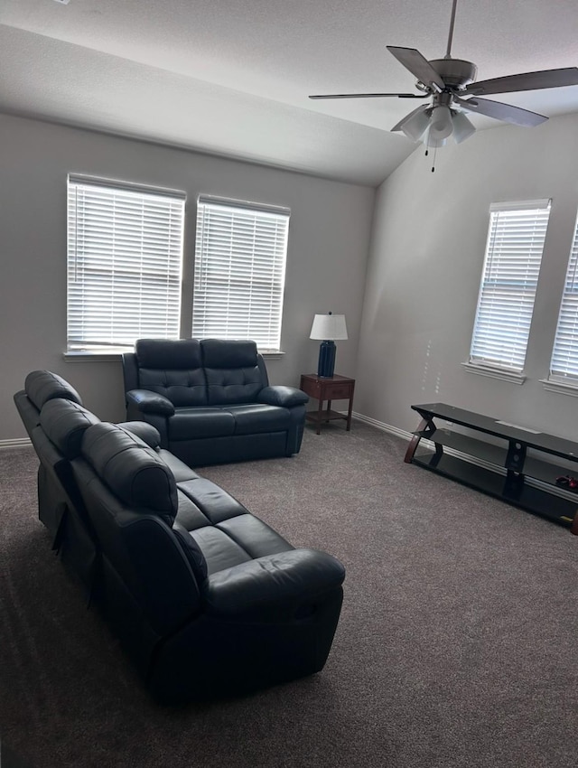 carpeted living room featuring ceiling fan, a wealth of natural light, and lofted ceiling