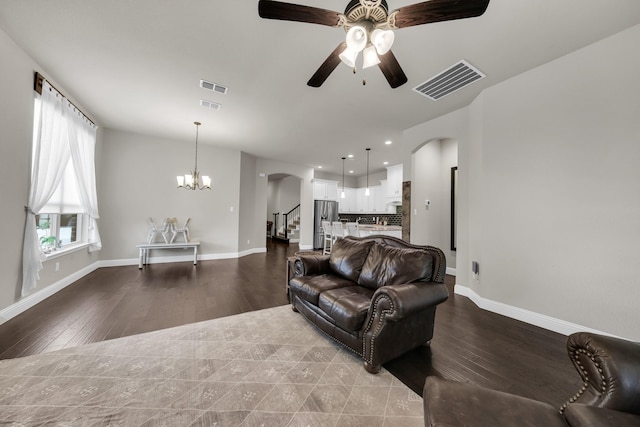 living room with ceiling fan with notable chandelier and light hardwood / wood-style flooring