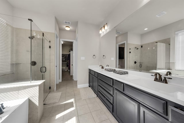 bathroom with walk in shower, vanity, and tile patterned flooring