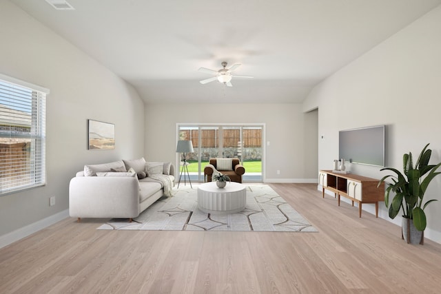 living room with light hardwood / wood-style flooring, ceiling fan, and vaulted ceiling