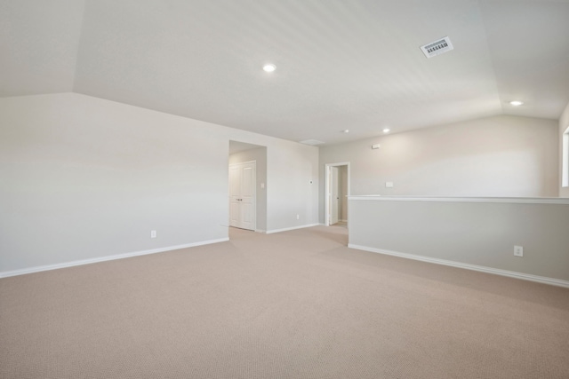 spare room with lofted ceiling and light colored carpet