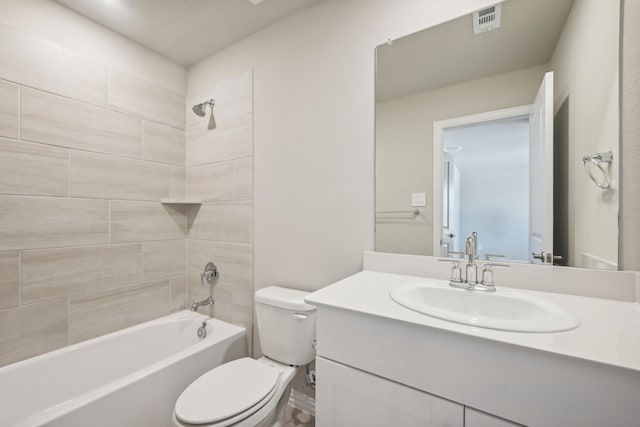 full bathroom with tiled shower / bath, vanity, and toilet