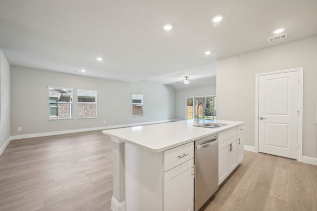 kitchen with white cabinetry, an island with sink, sink, stainless steel dishwasher, and light hardwood / wood-style floors