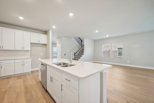 kitchen featuring sink, white cabinetry, a center island with sink, light hardwood / wood-style flooring, and dishwasher