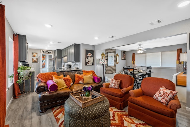 living room with ceiling fan and light hardwood / wood-style flooring