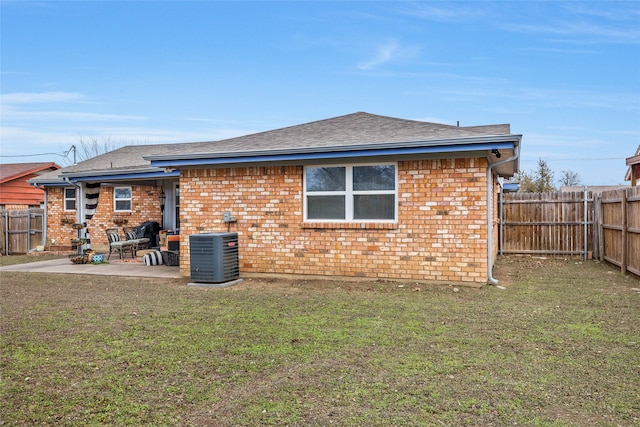 rear view of house featuring a patio area, cooling unit, and a yard