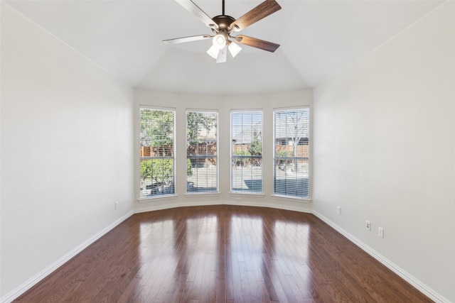 spare room with dark wood-type flooring, vaulted ceiling, and ceiling fan