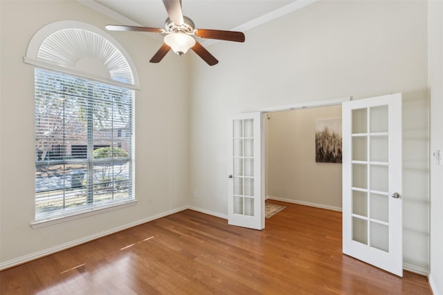 unfurnished room with wood-type flooring, ornamental molding, ceiling fan, and french doors