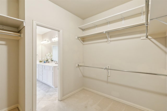 spacious closet featuring light carpet and sink