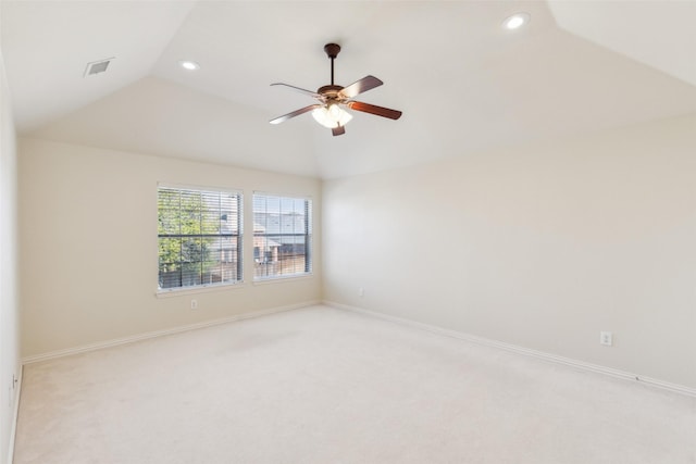 empty room with lofted ceiling, light colored carpet, and ceiling fan