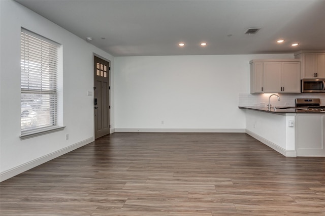 unfurnished living room featuring sink and light wood-type flooring