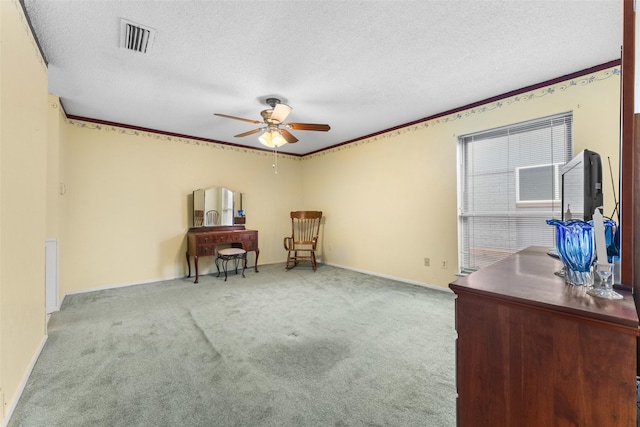 interior space featuring ceiling fan, light colored carpet, a textured ceiling, and crown molding