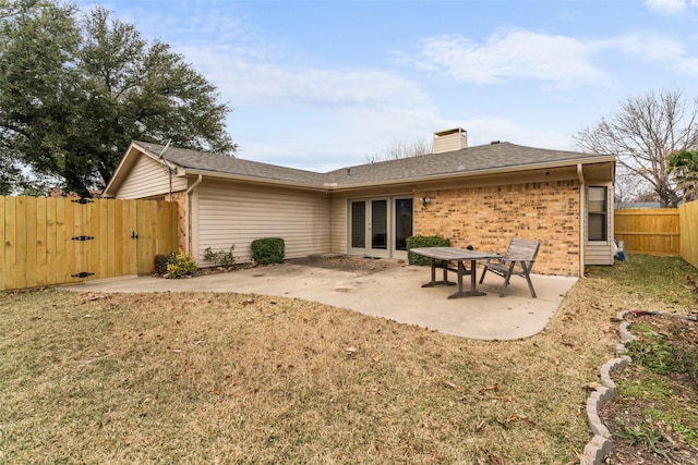 back of property with a lawn and a patio