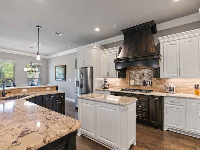 kitchen with a center island, premium range hood, white cabinetry, sink, and stainless steel appliances