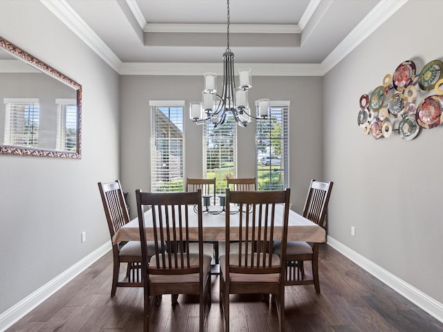 dining area featuring a notable chandelier, ornamental molding, and a tray ceiling