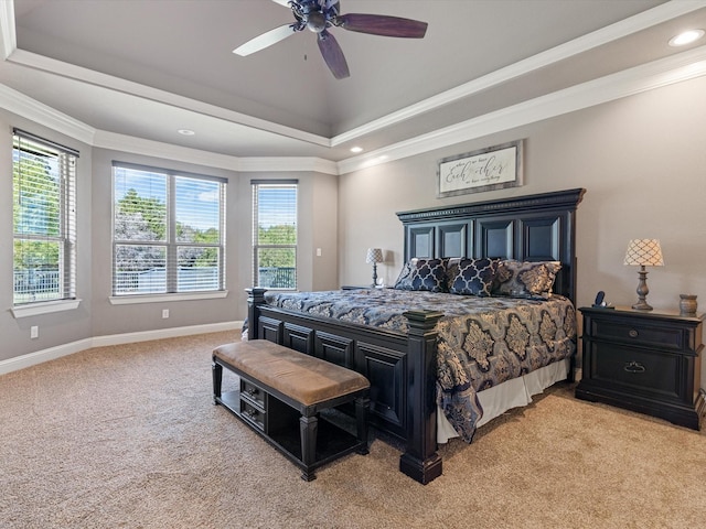 bedroom with ceiling fan, light colored carpet, ornamental molding, and a raised ceiling