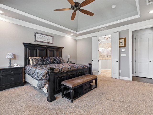 bedroom with ceiling fan, a raised ceiling, carpet, ensuite bath, and ornamental molding