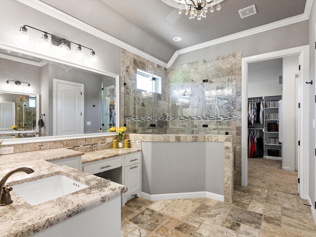 bathroom with lofted ceiling, vanity, ornamental molding, a notable chandelier, and tiled shower