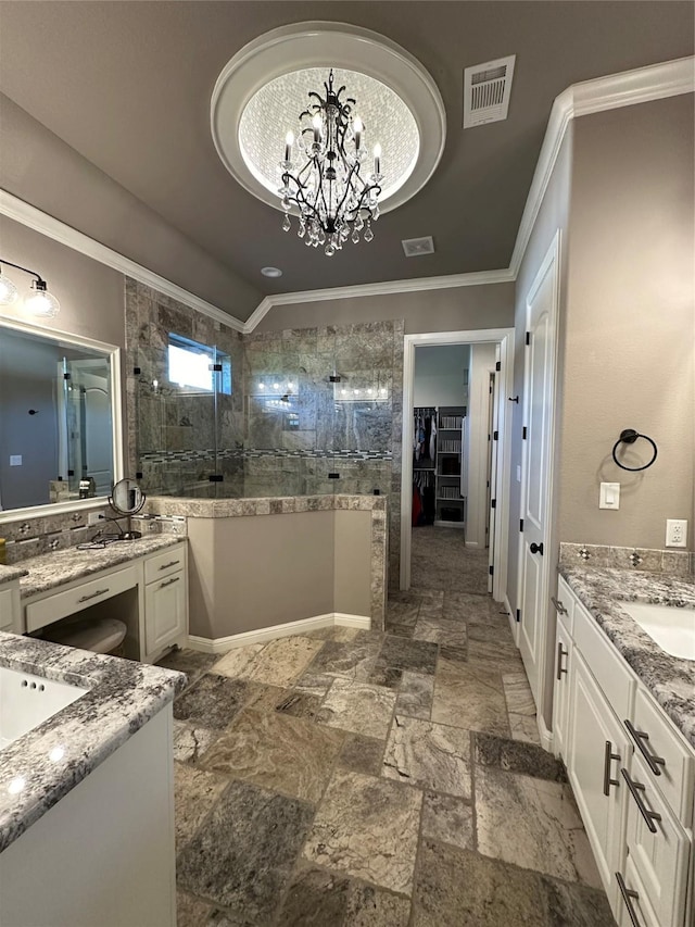 bathroom with a tile shower, ornamental molding, a notable chandelier, and vanity