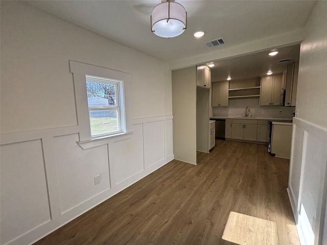 kitchen featuring stainless steel dishwasher, gray cabinets, sink, and light wood-type flooring