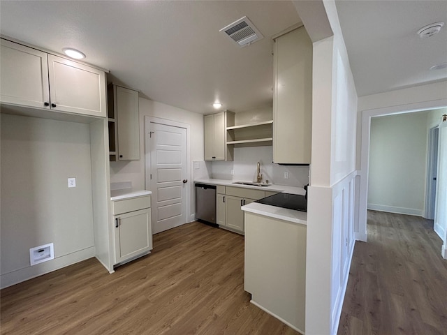 kitchen with dishwasher, sink, and light hardwood / wood-style flooring