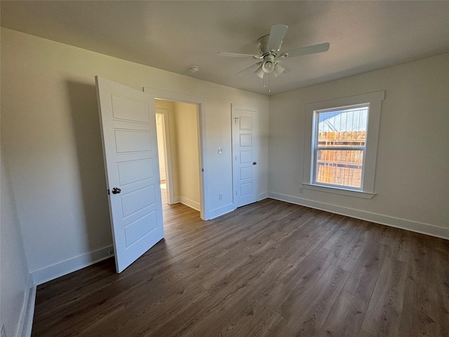 unfurnished bedroom with a closet, dark hardwood / wood-style floors, and ceiling fan