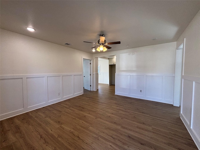 spare room with dark wood-type flooring and ceiling fan