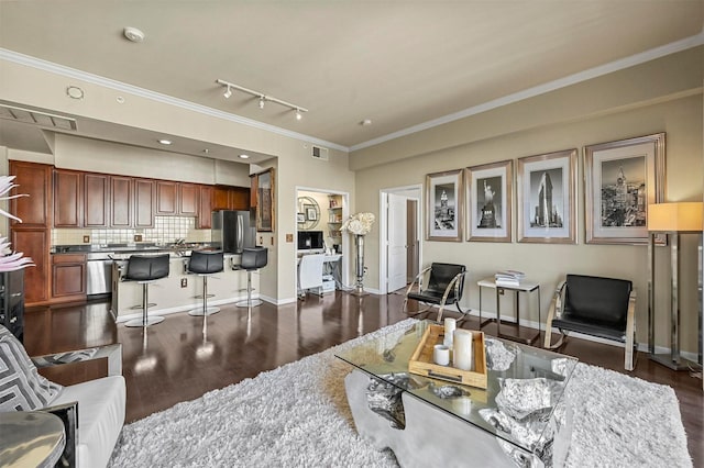 living room with rail lighting, dark hardwood / wood-style floors, and ornamental molding