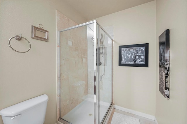 bathroom featuring toilet, walk in shower, and tile patterned floors