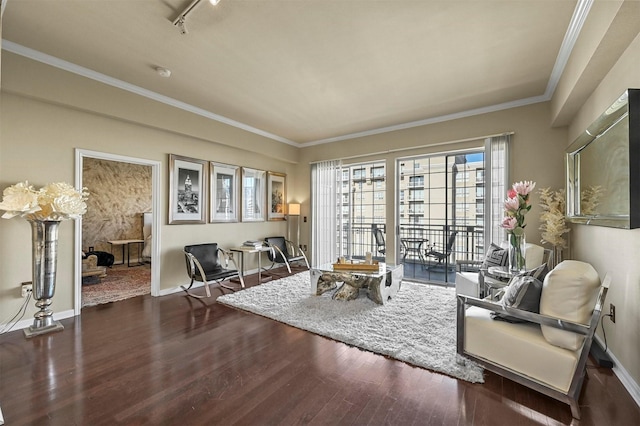 living area with track lighting, ornamental molding, and dark wood-type flooring