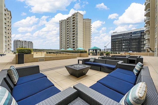 view of patio featuring an outdoor living space with a fire pit